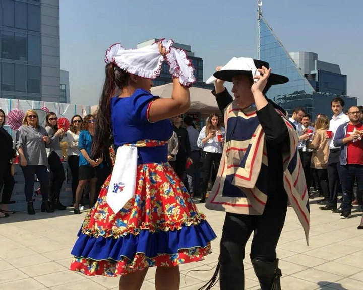 Pareja baila cueca con pañuelos durante una celebración de equipo