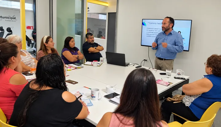 Facilitador conversa sobre bienestar con un grupo reunido alrededor de una mesa