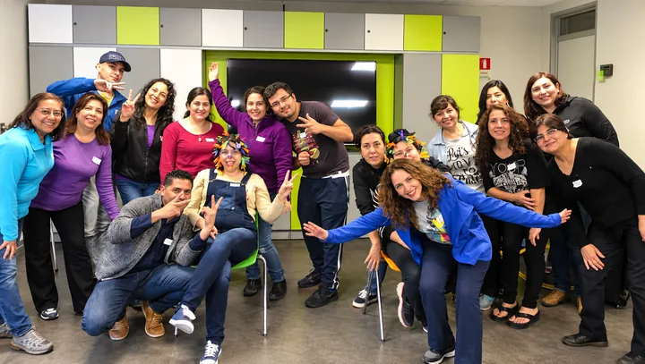 Equipo reunido posa al finalizar una actividad en una sala colorida